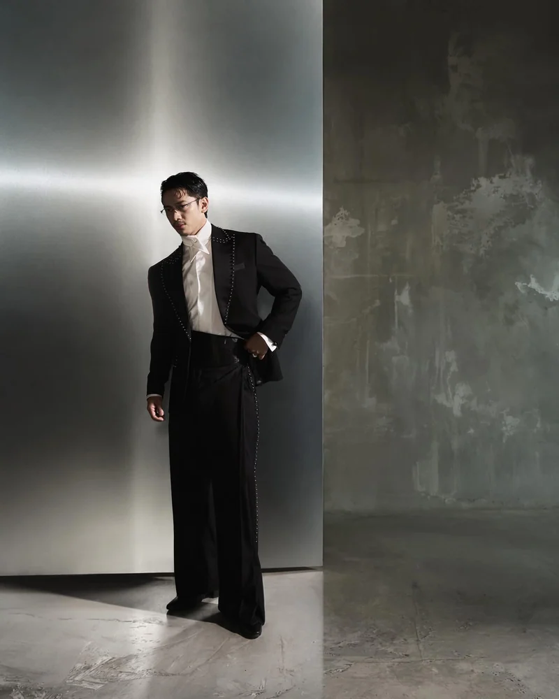 David Guison in ORIAS black bespoke tailoring against metal and concrete